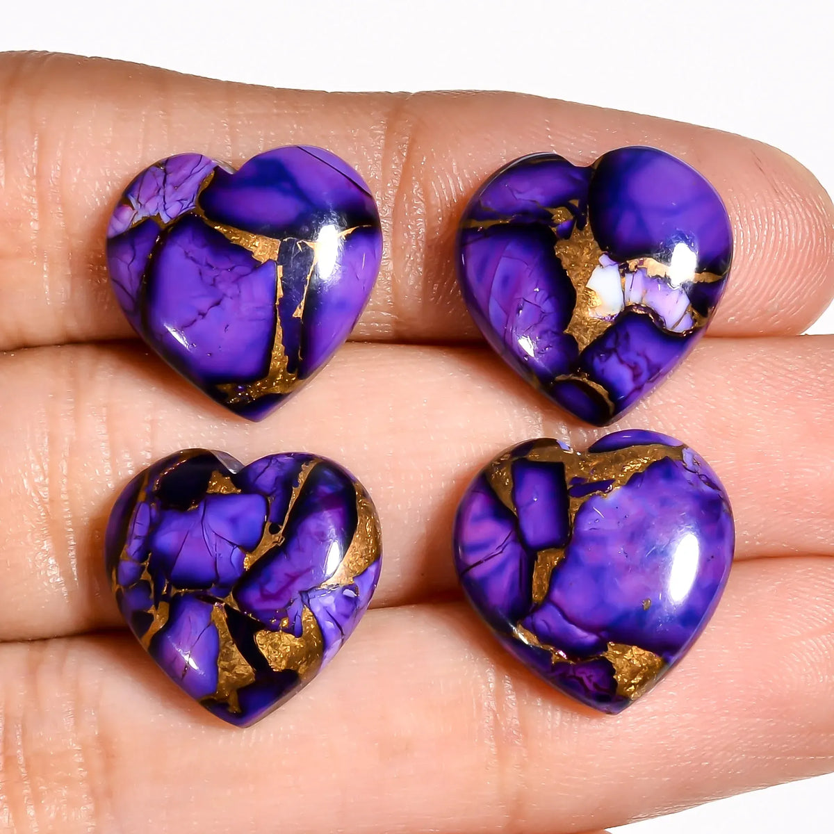 Purple turquoise gemstone hearts for jewelry making held on a hand to show 15 MM size