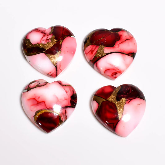 Red and pink copper turquoise gemstone hearts with glossy domed tops and gold veins, top view