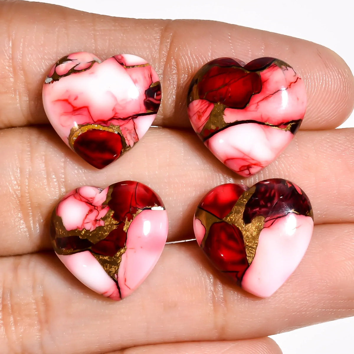 Red turquoise stones for jewelry making, heart gems held on a hand to show the 15 MM size