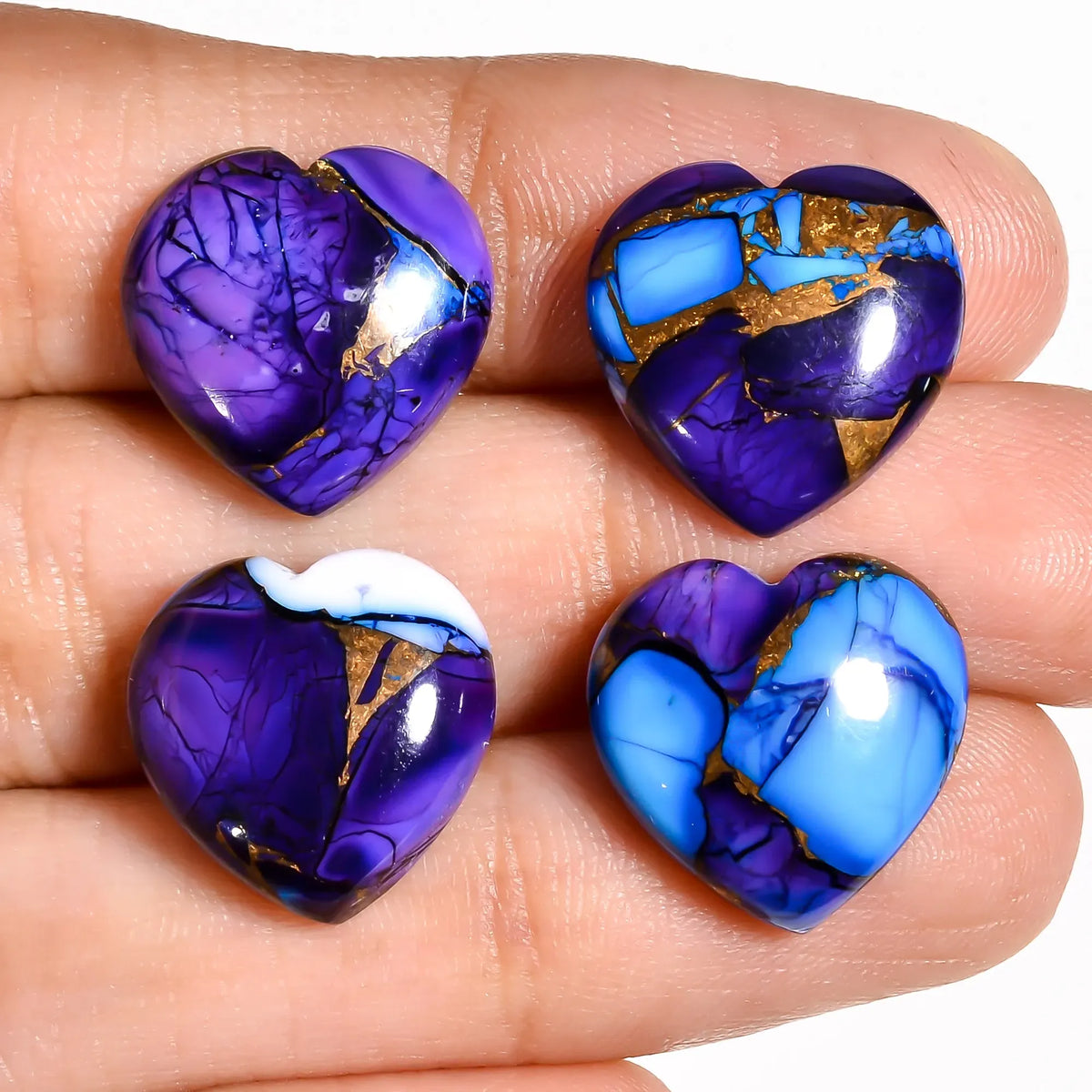 Purple and blue turquoise stones for jewelry making, heart cabochons held on a hand to show 15 MM size